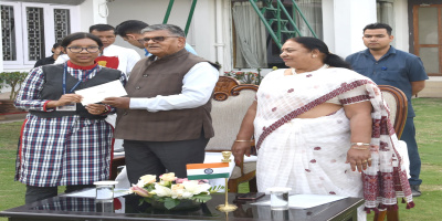 Governor distributing educational grants to a student of Raj Bhavan employee